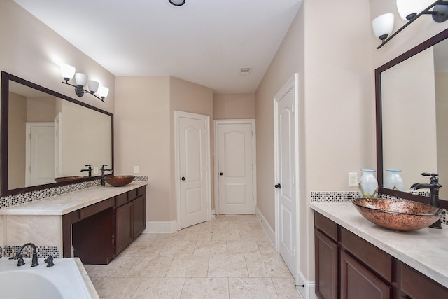 6034 Gracys Landing Ln, Katy, TX 77494 - full bathroom featuring two vanities, a bathtub, decorative backsplash, and a closet