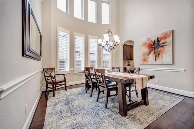 10210 Grape Creek Grove Ln, Cypress, TX 77433 - dining room with a chandelier, dark wood-style floors, arched walkways, and a towering ceiling