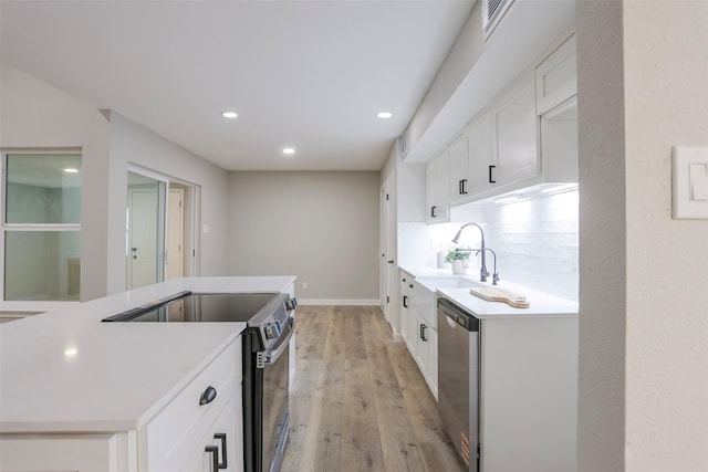 10260 Field Stone Dr, Houston, TX 77041 - kitchen with appliances with stainless steel finishes, light wood finished floors, recessed lighting, light countertops, and white cabinets