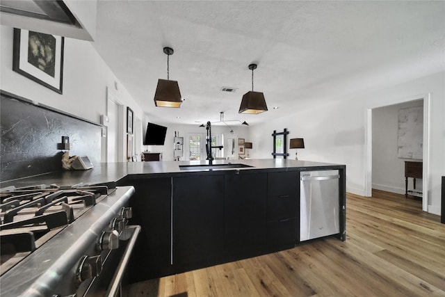 5503 Cheshire Ln, Houston, TX 77092 - kitchen with stainless steel appliances, dark cabinets, light wood finished floors, and dark countertops
