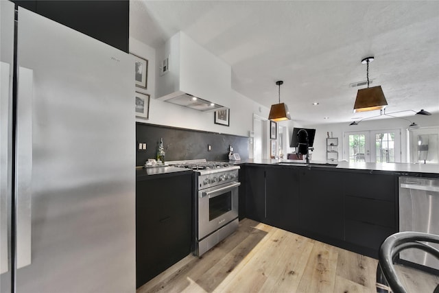 5503 Cheshire Ln, Houston, TX 77092 - kitchen featuring stainless steel appliances, dark cabinets, light wood finished floors, modern cabinets, and dark countertops