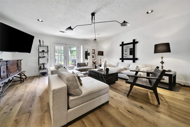 5503 Cheshire Ln, Houston, TX 77092 - living room with light wood-style floors, recessed lighting, french doors, and a textured ceiling