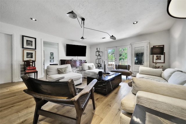 5503 Cheshire Ln, Houston, TX 77092 - living room featuring light wood-style flooring, a textured ceiling, and recessed lighting