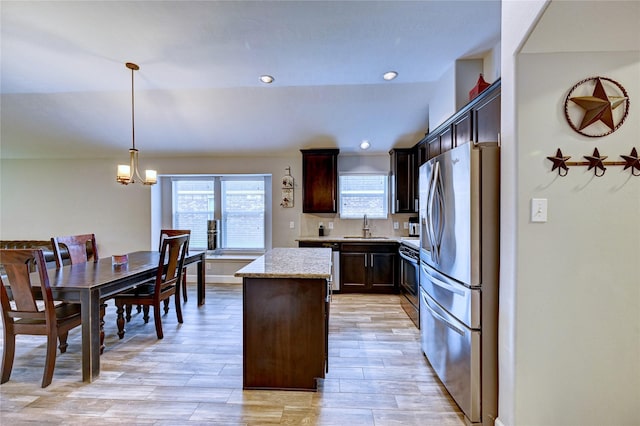 5311 Persimmon Pass, Richmond, TX 77407 - kitchen featuring stainless steel appliances, a kitchen island, dark brown cabinetry, light wood-type flooring, and pendant lighting