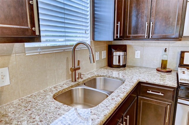 5311 Persimmon Pass, Richmond, TX 77407 - kitchen featuring dark brown cabinets, tasteful backsplash, and light stone countertops