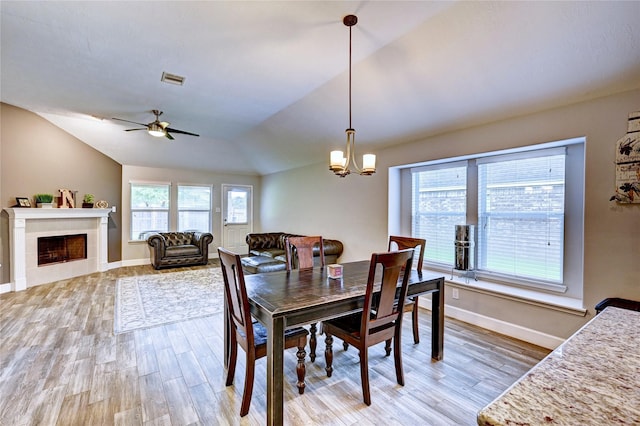 5311 Persimmon Pass, Richmond, TX 77407 - dining space with light wood-style floors, lofted ceiling, a chandelier, a tile fireplace, and ceiling fan