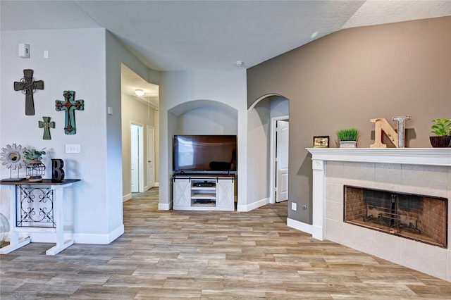 5311 Persimmon Pass, Richmond, TX 77407 - living area with wood finished floors, a tiled fireplace, and vaulted ceiling