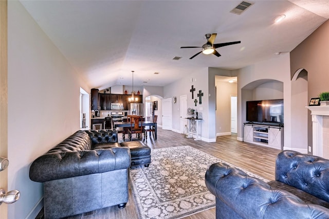 5311 Persimmon Pass, Richmond, TX 77407 - living room with a ceiling fan, wood finished floors, arched walkways, and vaulted ceiling