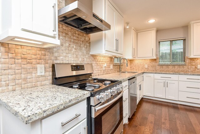 5815 Dryad Dr, Houston, TX 77035 - kitchen with stainless steel appliances, ventilation hood, white cabinets, dark wood finished floors, and light stone counters