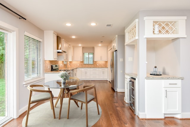 5815 Dryad Dr, Houston, TX 77035 - kitchen with stainless steel appliances, beverage cooler, backsplash, white cabinetry, and light stone counters