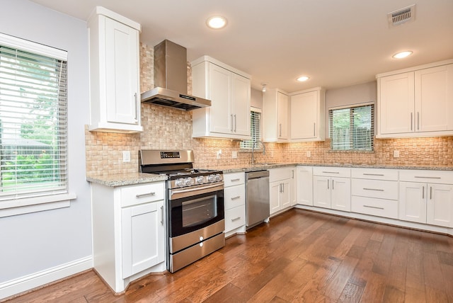 5815 Dryad Dr, Houston, TX 77035 - kitchen with wall chimney range hood, stainless steel appliances, white cabinets, and recessed lighting