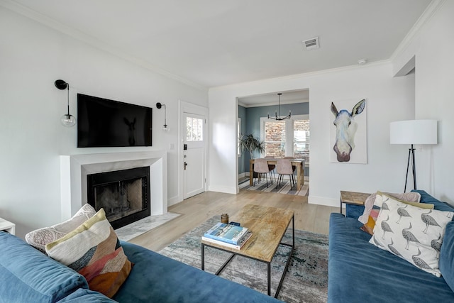 1917 Brun St, Houston, TX 77019 - living room featuring a chandelier, crown molding, wood finished floors, and a premium fireplace
