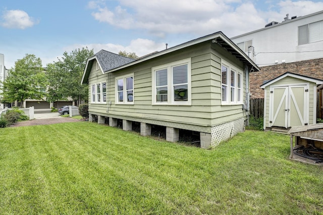 1917 Brun St, Houston, TX 77019 - rear view of house with a storage unit, a lawn, roof with shingles, and a garage