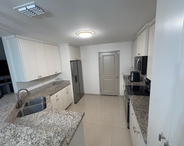 3237 Zircon Dr, Edinburg, TX 78541 - kitchen with stainless steel appliances, white cabinetry, light tile patterned floors, and stone counters