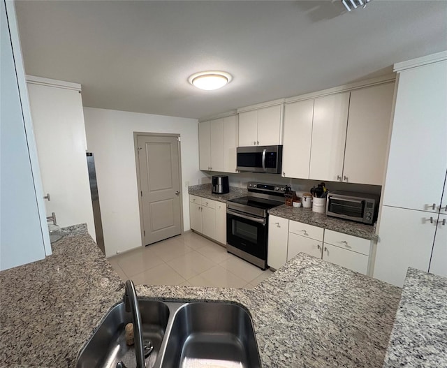 3237 Zircon Dr, Edinburg, TX 78541 - kitchen featuring appliances with stainless steel finishes, white cabinetry, light tile patterned floors, and stone counters