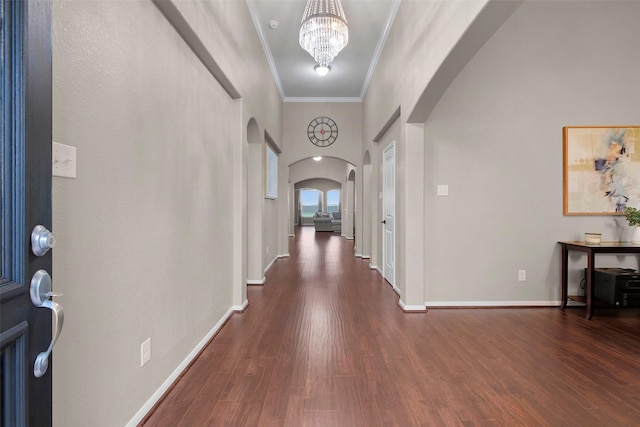7518 Tejas Lakes Trl, Needville, TX 77461 - entrance foyer with arched walkways, crown molding, dark wood-style floors, a chandelier, and a high ceiling