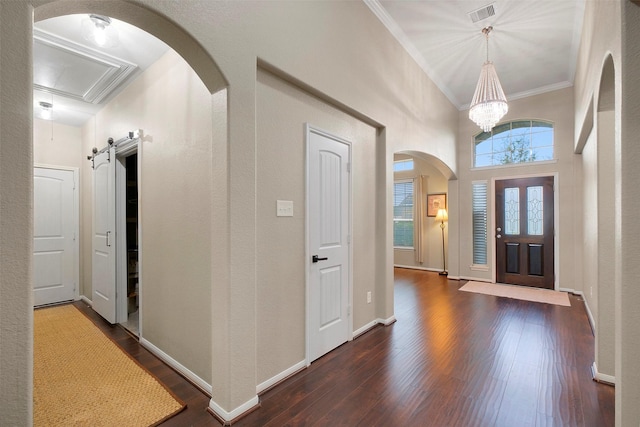 7518 Tejas Lakes Trl, Needville, TX 77461 - entrance foyer with ornamental molding, dark wood-type flooring, arched walkways, and a chandelier