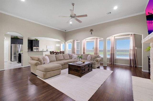 7518 Tejas Lakes Trl, Needville, TX 77461 - living room featuring ceiling fan, arched walkways, plenty of natural light, dark wood-style floors, and crown molding