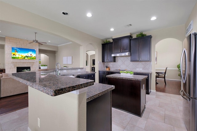 7518 Tejas Lakes Trl, Needville, TX 77461 - kitchen featuring a large island, stainless steel appliances, ceiling fan, under cabinet range hood, and open floor plan