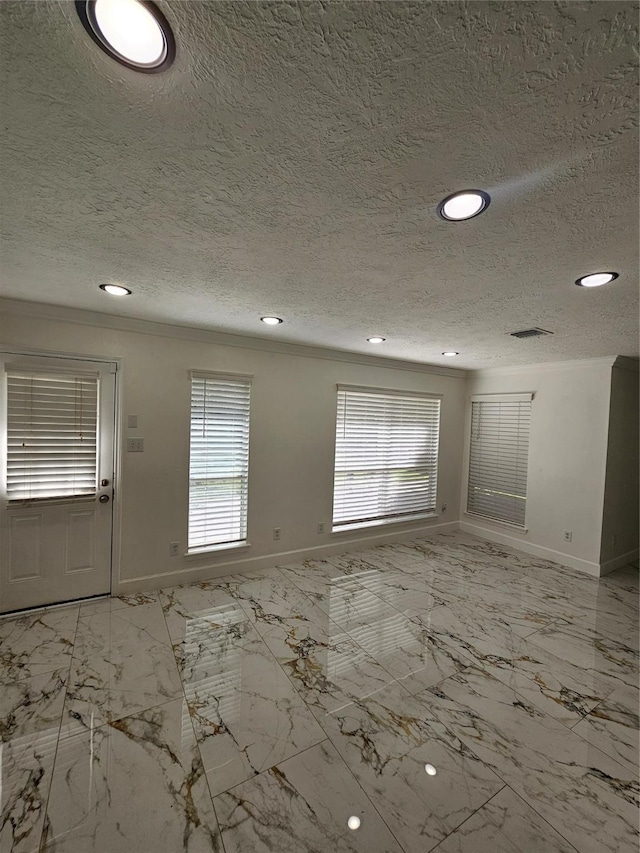 9207 Dairy View Ln, Houston, TX 77099 - unfurnished room featuring ornamental molding, a textured ceiling, recessed lighting, healthy amount of natural light, and light marble finish floors