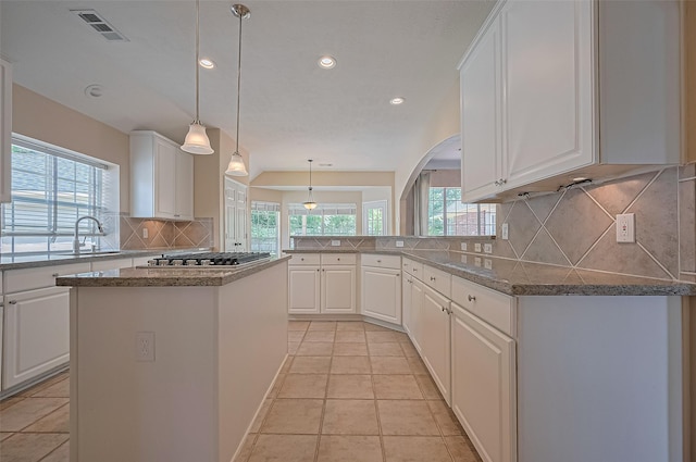 14610 Sandler Ct, Cypress, TX 77429 - kitchen featuring stainless steel gas cooktop, plenty of natural light, decorative backsplash, recessed lighting, and white cabinetry