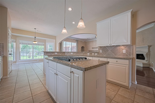 14610 Sandler Ct, Cypress, TX 77429 - kitchen featuring stainless steel gas stovetop, arched walkways, tasteful backsplash, white cabinetry, and recessed lighting