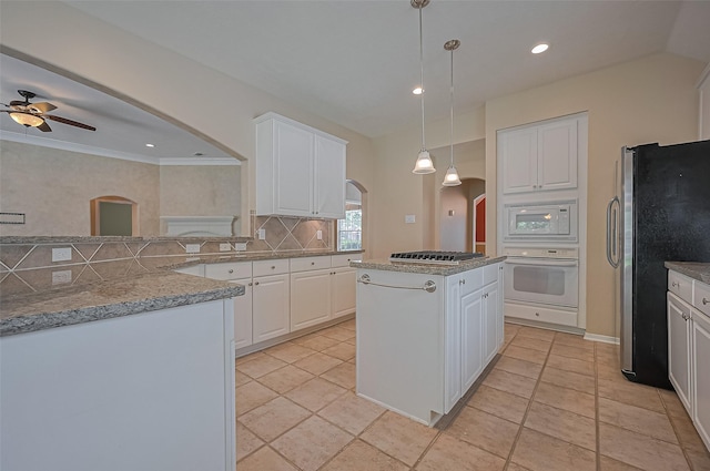 14610 Sandler Ct, Cypress, TX 77429 - kitchen with stainless steel appliances, arched walkways, backsplash, a center island, and white cabinetry