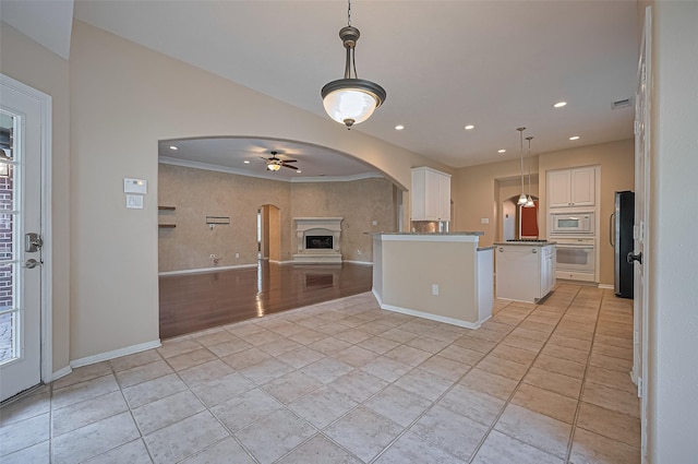 14610 Sandler Ct, Cypress, TX 77429 - kitchen with white appliances, arched walkways, open floor plan, ceiling fan, and white cabinets