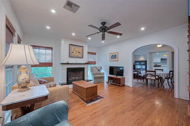 501 Gale St, Houston, TX 77009 - living room with arched walkways, a ceiling fan, light wood-style flooring, recessed lighting, and a fireplace with raised hearth