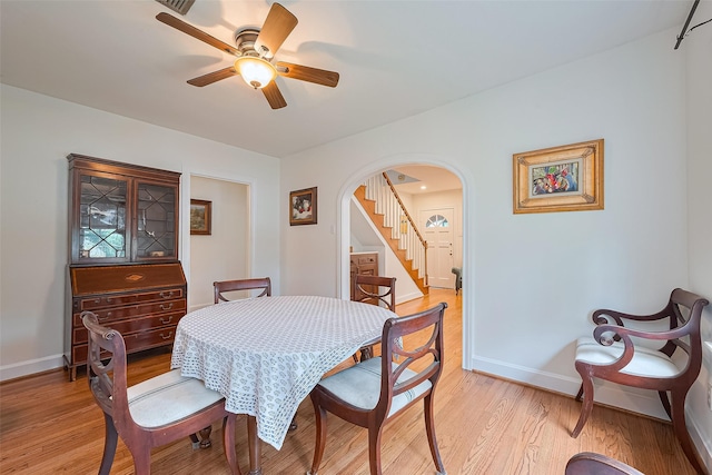 501 Gale St, Houston, TX 77009 - dining area featuring arched walkways, ceiling fan, light wood-type flooring, and stairway