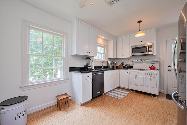 501 Gale St, Houston, TX 77009 - kitchen featuring appliances with stainless steel finishes, white cabinetry, dark countertops, and pendant lighting