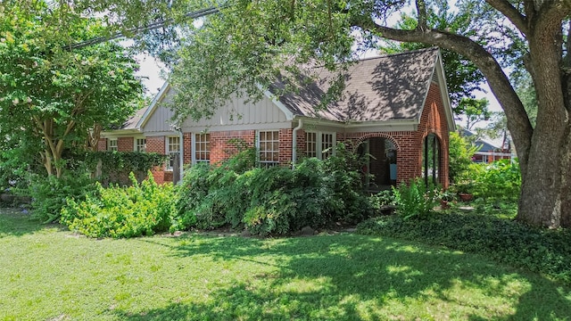 501 Gale St, Houston, TX 77009 - view of side of home featuring brick siding, a yard, board and batten siding, and roof with shingles