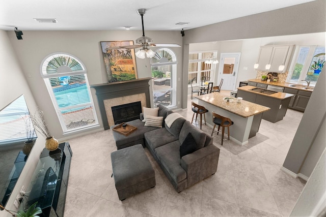 23 Sparklewood Pl, The Woodlands, TX 77381 - living area with plenty of natural light, a tiled fireplace, a ceiling fan, and light tile patterned floors