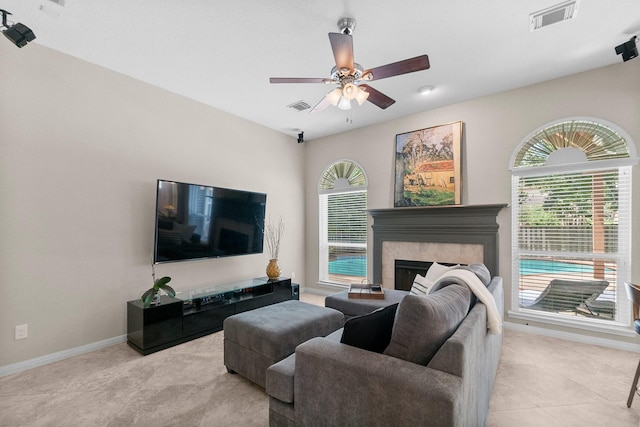 23 Sparklewood Pl, The Woodlands, TX 77381 - living room featuring healthy amount of natural light, a fireplace, a ceiling fan, and tile patterned flooring