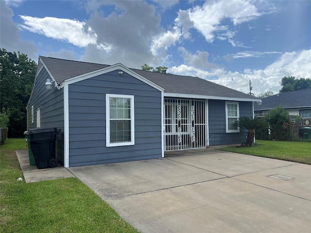7001 Kassarine Pass, Houston, TX 77033 - view of front facade with a patio area, a front yard, and roof with shingles