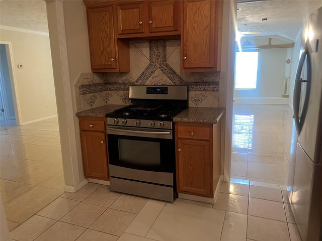 7001 Kassarine Pass, Houston, TX 77033 - kitchen featuring stainless steel appliances, brown cabinetry, tasteful backsplash, ornamental molding, and dark stone countertops
