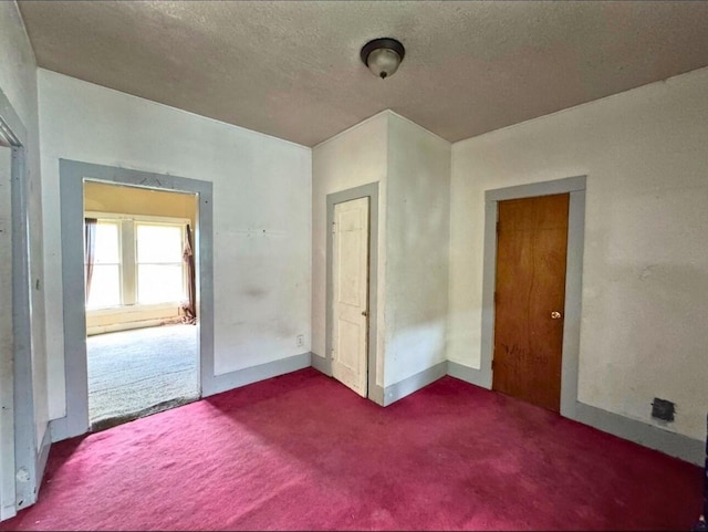 3215 Illinois St, Baytown, TX 77520 - unfurnished bedroom featuring dark colored carpet and a textured ceiling