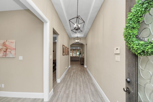 203 Pinedale Ave, Arcola, TX 77583 - corridor with light wood finished floors, arched walkways, and a chandelier