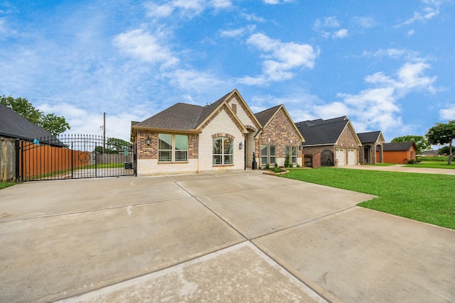 203 Pinedale Ave, Arcola, TX 77583 - french country style house with concrete driveway, a gate, brick siding, and stone siding