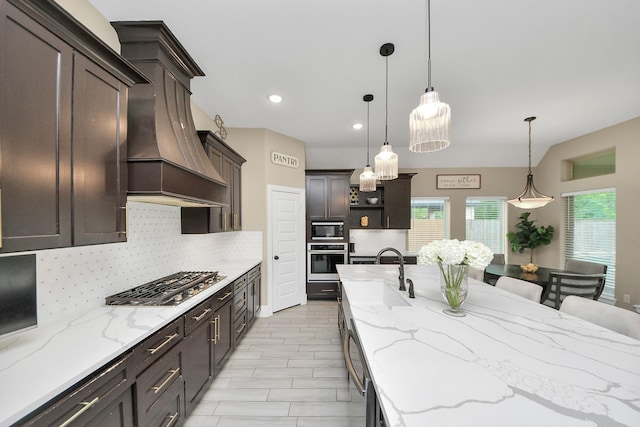 203 Pinedale Ave, Arcola, TX 77583 - kitchen featuring appliances with stainless steel finishes, open shelves, tasteful backsplash, dark brown cabinets, and hanging light fixtures