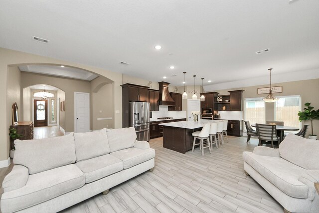 203 Pinedale Ave, Arcola, TX 77583 - living area with arched walkways, light wood-style flooring, and recessed lighting