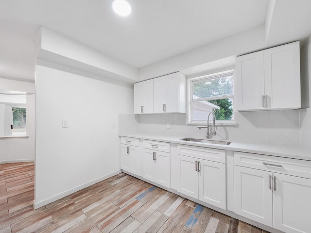5010 Riverview Dr, Alvin, TX 77511 - kitchen featuring light countertops, light wood finished floors, and white cabinetry