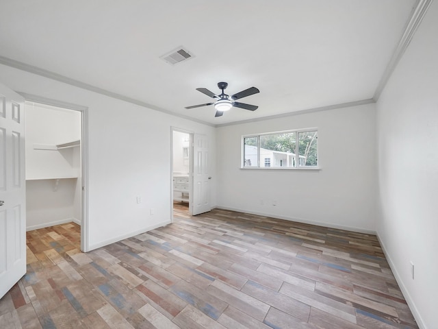 5010 Riverview Dr, Alvin, TX 77511 - unfurnished bedroom with light wood finished floors, a walk in closet, a ceiling fan, ornamental molding, and connected bathroom