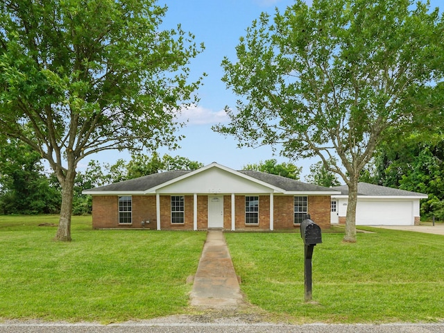 5010 Riverview Dr, Alvin, TX 77511 - view of front of house with concrete driveway, a front yard, a garage, and brick siding