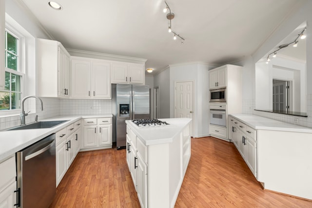 1922 Stormcroft Cir, Katy, TX 77450 - kitchen featuring appliances with stainless steel finishes, ornamental molding, rail lighting, white cabinets, and recessed lighting