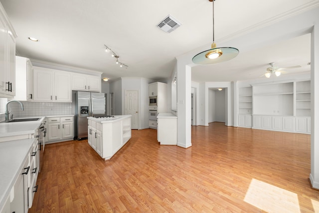 1922 Stormcroft Cir, Katy, TX 77450 - kitchen with stainless steel appliances, a ceiling fan, white cabinetry, light countertops, and light wood finished floors