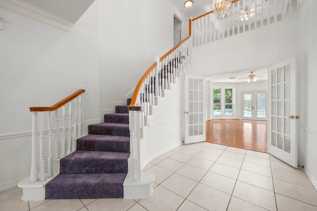 1922 Stormcroft Cir, Katy, TX 77450 - stairway with french doors, a towering ceiling, tile patterned flooring, ceiling fan, and crown molding