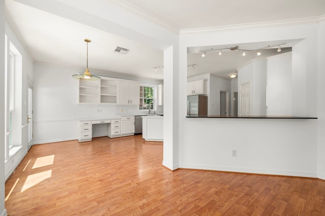 1922 Stormcroft Cir, Katy, TX 77450 - unfurnished living room with rail lighting, built in desk, light wood-style flooring, and ornamental molding