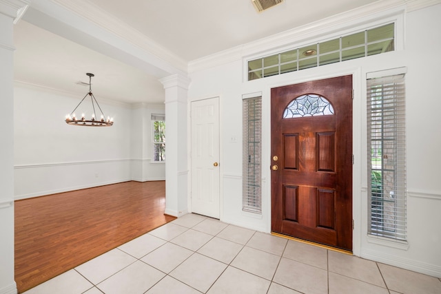 1922 Stormcroft Cir, Katy, TX 77450 - foyer featuring a chandelier, ornamental molding, decorative columns, and light wood finished floors