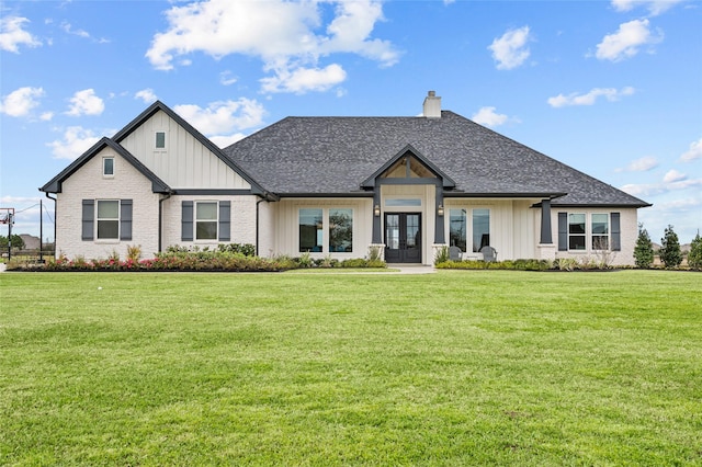 14923 Old Irish Farm Rd, Baytown, TX 77523 - view of front facade with french doors, a chimney, board and batten siding, and a front lawn